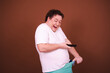 Funny fat man takes indecent photos. A man has strong emotions. Brown background.