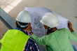 © DusanJelicic - Woman architect and men contractor examining plans on construction site.