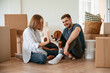 © standret - Happy young couple with dog are moving to new home. On the floor