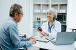 © Nuttapong punna - Senior man being examined by a doctor sitting at the table. Medicine and health care concept.