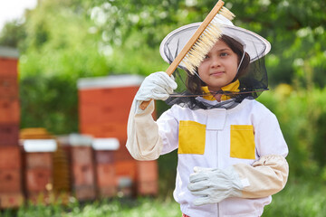 Wall Mural - Girl analyzing hive brush at apiary garden