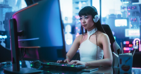 Creative Japanese Female Using Desktop Computer in a Futuristic High Tech Office Space. Young Asian Female Working on Artistic Digital Projects, Browsing Internet or Shopping Online