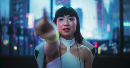 Stylish Japanese Young Woman Interacting with Augmented Reality Platform in a Technologically Advanced Room with Futuristic Cyberpunk City in the Background. She is Checking Social Media
