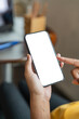 © Natee Meepian - Close up image of female hands using smartphone with blank white screen in the home