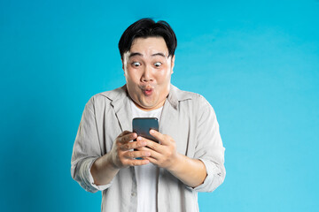image of asian man using phone on blue background