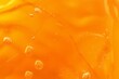Texture of white yellow gel with air bubbles and waves on orange background. Concept of skin moisturizing, body care. Liquid beauty product closeup. Backdrop, flat, Generative AI