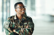 © aLListar/peopleimages.com - Soldier with smile, confidence and arms crossed at army building, pride and happy professional in sevice. Military career, security and courage, black man in camouflage uniform at government agency.
