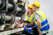 © FotoArtist - Industrial worker indoors in factory. Young technician with orange hard hat. Smart Caucasian factory worker wearing hardhat and working in power plant.