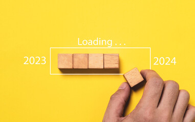 Wall Mural - hand assemble wooden block cube to update progress 2023 to 2024 for countdown and preparation new ye