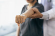 © Wasan - Doctor practicing arm and shoulder physiotherapy for female patient in hospital.