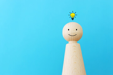 Wall Mural - bright light bulb and wooden figure over blue background concept image of