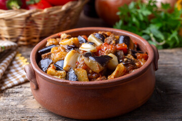 Wall Mural - Top view of Turkish dish Guvech - baked meat with eggplant and traditionally served in earthenware pot (Turkish name; etli patlican guvec)