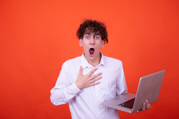 Wall Mural - Study and work. Attractive curly student posing on an orange background.