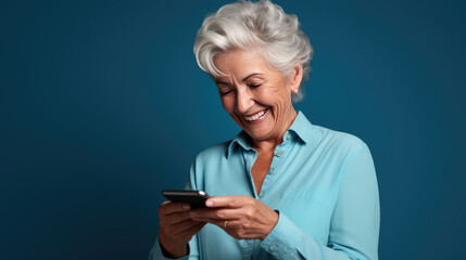 Wall Mural - An elderly woman smiling and laughing with her phone against a colored background.