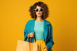 © PRASANNAPIX - Young woman wearing sunglasses and holding shopping bags