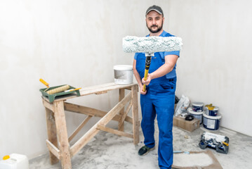 Worker builder posing with paint roller