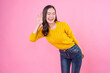 Young pretty attractive smart smiling curious caucasian woman 20s wearing casual knitted yellow sweater try to hear you overhear listening intently isolated on grey color background studio portrait