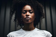 Portrait of young beautiful African American woman looking at camera with serious face on dark background.