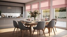 Gray roman shades and a pink curtain on large glass windows in a contemporary kitchen and dining room with a wooden table and white chairs.