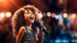 © Maria Moroz - charming girl child singing emotionally at a concert in front of a microphone, illuminated by spotlights, against backdrop of enthusiastic spectators.