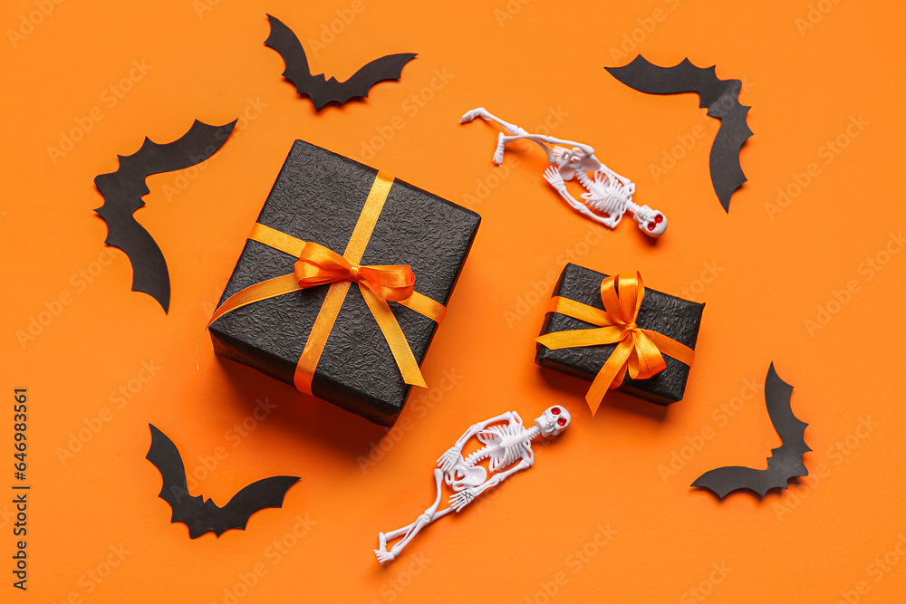 Composition with gift boxes and Halloween decorations on orange background