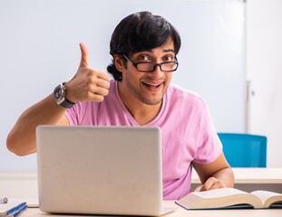 Wall Mural - Young male student sitting in the class