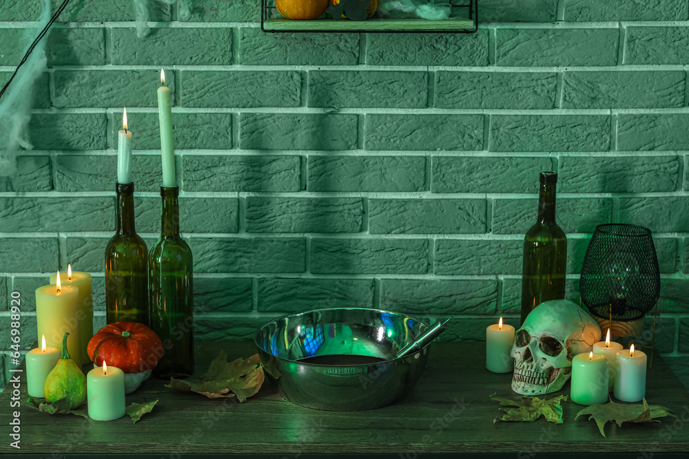 Burning candles with pumpkins and Halloween decor on table in dark room