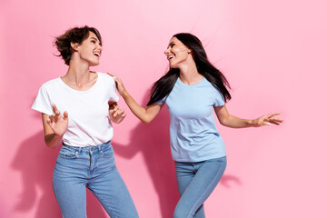 Wall Mural - Photo two careless girls dancing party have fun positive good mood shopaholic black friday advert promo isolated on pink color background