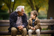 © AspctStyle - Happy grandson talking to his grandfather while sit in public park