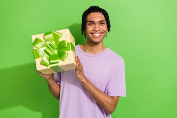 Canvas Print - Portrait of funky friendly positive person beaming smile arms hold giftbox isolated on green color background