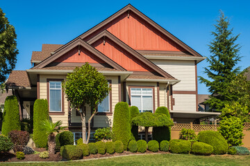 Big modern custom made luxury house with nicely landscaped front yard in summer. Beautiful house entrance with a garden