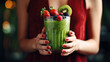 A glass of red and green smoothies in female hands, close-up.