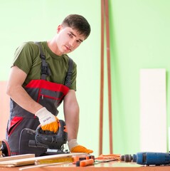 Wall Mural - Young man carpenter working in workshop