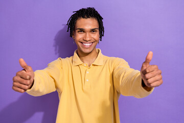 Wall Mural - Photo of positive glad man wear yellow trendy clothes demonstrate two hands thumbs up cool feedback isolated on purple color background