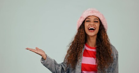 Canvas Print - Fashion, open hand and face of woman in studio with trendy hat for deal, promotion and sale. Advertising, mockup and portrait of happy person with style, casual clothes and outfit on gray background