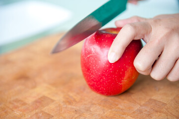 Wall Mural - The cook has cut red pepper and starts to cut apple.