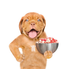 Poster - Funny Mastiff puppy holds bowl with popcorn. isolated on white background