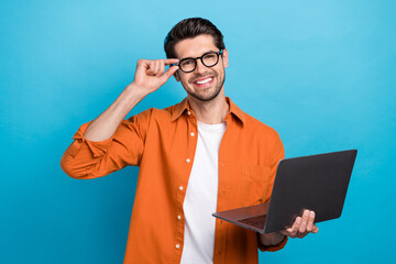 Fototapete - Photo of positive intelligent lawyer toothy smile arm touch eyeglasses hold netbook isolated on blue color background