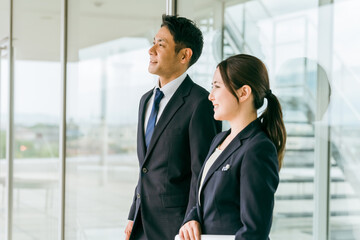 Poster - 会社で話すビジネスマンとビジネスウーマン（横顔）
