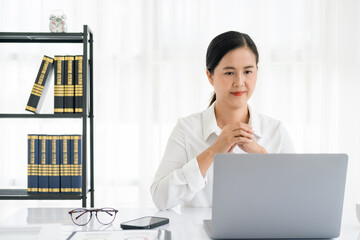 Asian young female working on laptop at office