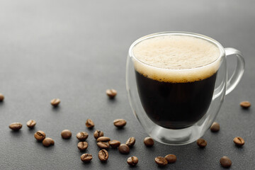 Wall Mural - glass cup of espresso and coffee beans on grey table