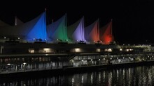 Vancouver, British Columbia - August 14, 2023: Canada Place At Night. Colorful Illuminated Sails. Lights Reflecting On Water Surface