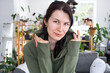 © Ольга Симонова - Large portrait Joyful emotions of a woman in the hood in her home in a bright modern interior with home plants. Eco-friendly portrait with real joy