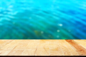 Wall Mural - Empty wooden table top and blurred swimming pool background.