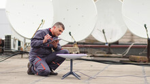 A Man Installs A Satellite Dish For Fast Internet.