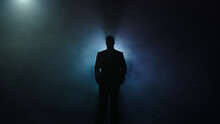 Silhouette Of A Handsome, Stylish Man Posing On A Dark Background In A Business Suit
