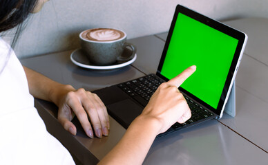 Poster - Close up of freelencer working on laptop computer with mock up green screen chroma key display in cafe.