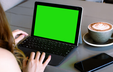 Poster - Close up of businesswoman using laptop computer with mock up green screen chroma key display in cafe.