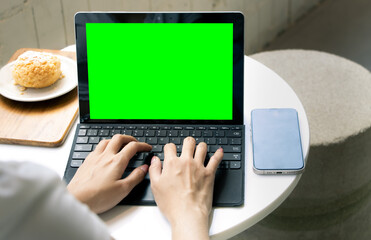 Poster - Close Up woman Working on Laptop computer with Green Screen Mock Up Display at cafe while Sitting at a Table, Iot, online business.