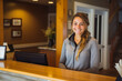 © VisualProduction - Young caucasian female bed and breakfast owner standing behind welcome desk.